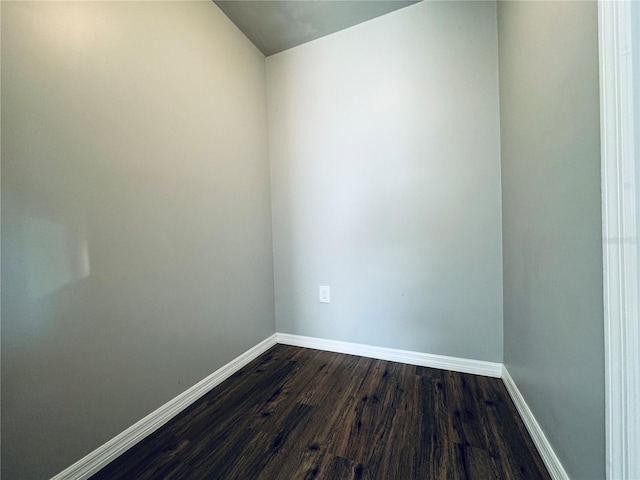 empty room with dark wood-type flooring and baseboards