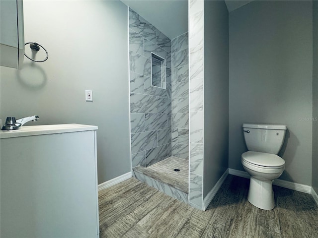1409 Franklin St, Clearwater, FL 33756 - full bathroom featuring baseboards, walk in shower, toilet, wood finished floors, and vanity