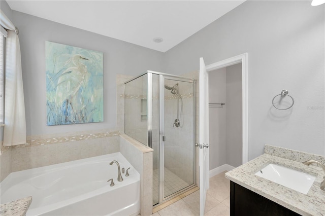 bathroom with vanity, a shower stall, a garden tub, and tile patterned floors