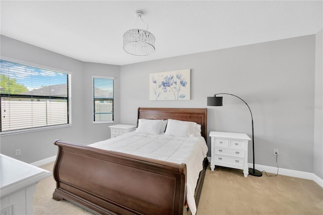 bedroom with light colored carpet and baseboards