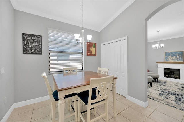 dining space featuring arched walkways, a chandelier, light tile patterned flooring, and vaulted ceiling