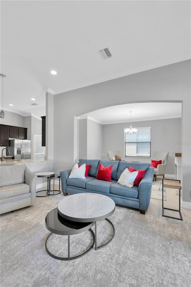 living room with a notable chandelier, recessed lighting, crown molding, and baseboards