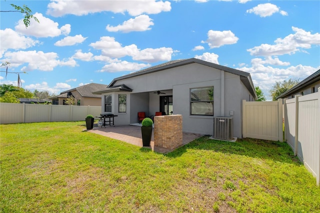 rear view of property with a fenced backyard, central AC unit, a patio, and a yard