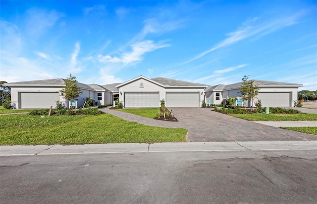 ranch-style home featuring a garage, a front yard, driveway, and stucco siding