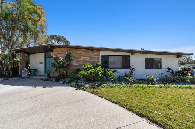 view of front of house featuring a front lawn, concrete driveway, and stucco siding