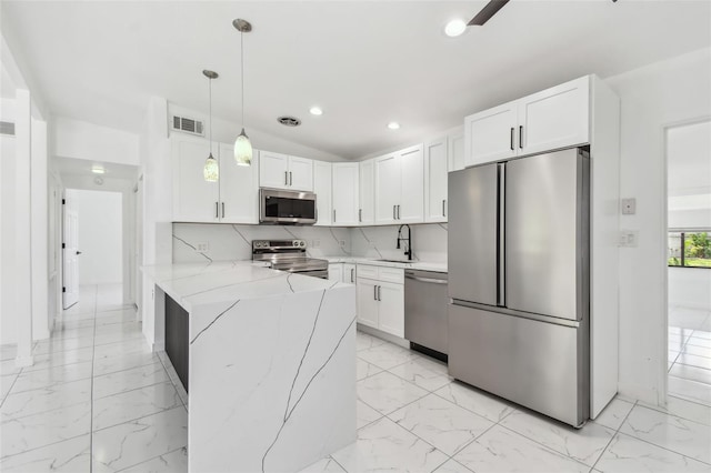 kitchen with a sink, stainless steel appliances, marble finish floor, and a peninsula