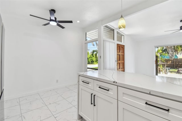 kitchen featuring baseboards, ceiling fan, light stone countertops, white cabinets, and marble finish floor