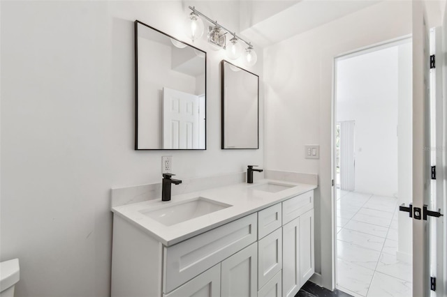 bathroom with a sink, marble finish floor, and double vanity