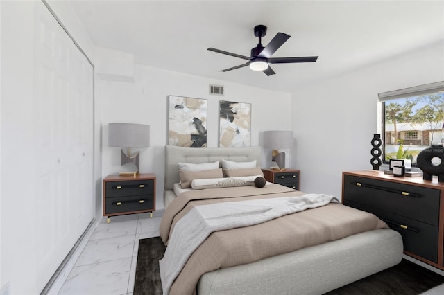bedroom featuring a closet, visible vents, marble finish floor, and ceiling fan
