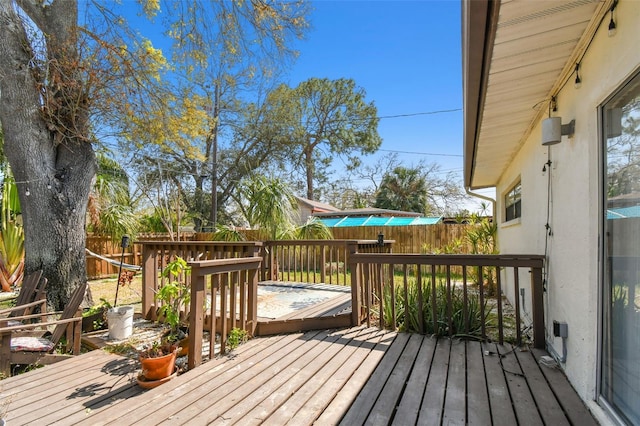 wooden deck with a fenced backyard
