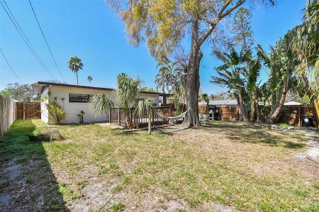 view of yard with a fenced backyard and a wooden deck