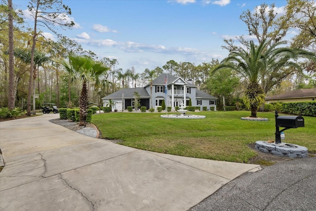 view of front of property featuring concrete driveway and a front lawn