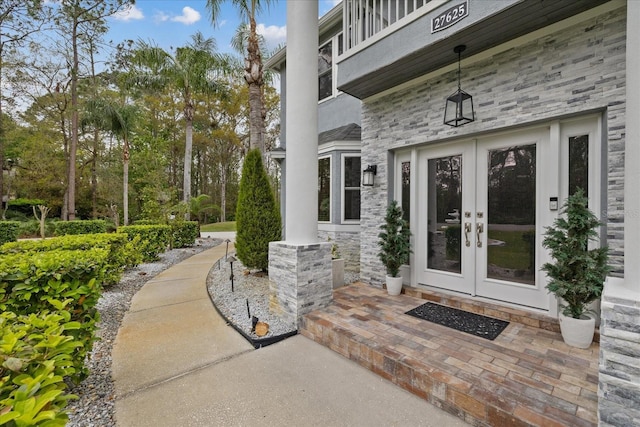 view of exterior entry featuring french doors and stone siding