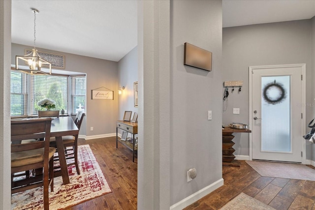 entryway with baseboards, a chandelier, and dark wood finished floors