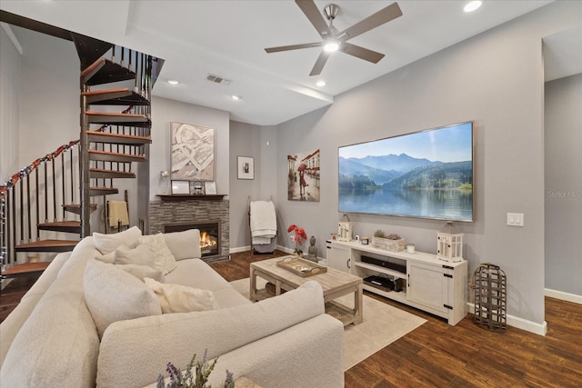 living area with visible vents, dark wood-style floors, a fireplace, and stairs