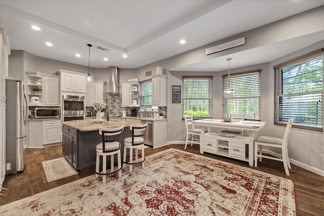 kitchen with visible vents, appliances with stainless steel finishes, white cabinetry, wall chimney exhaust hood, and open shelves