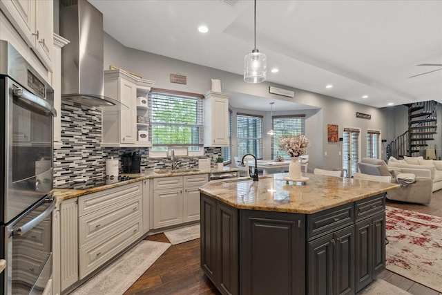 kitchen featuring a sink, backsplash, black electric stovetop, wall chimney range hood, and dark wood-style flooring