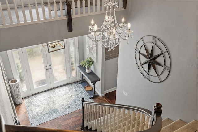 entryway featuring stairway, wood finished floors, baseboards, french doors, and a notable chandelier