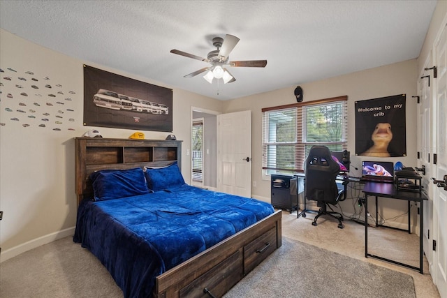 bedroom featuring baseboards, light carpet, a textured ceiling, and ceiling fan