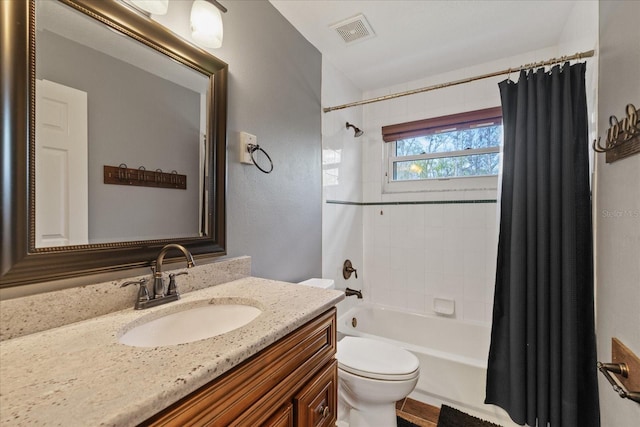 full bathroom featuring visible vents, shower / bath combo with shower curtain, toilet, and vanity