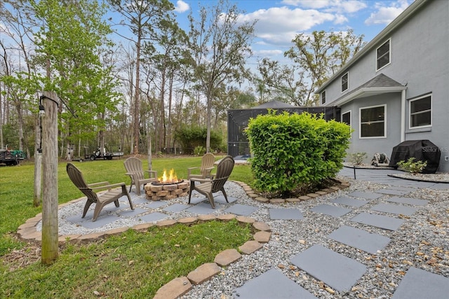 view of yard with a patio area, a lanai, and an outdoor fire pit