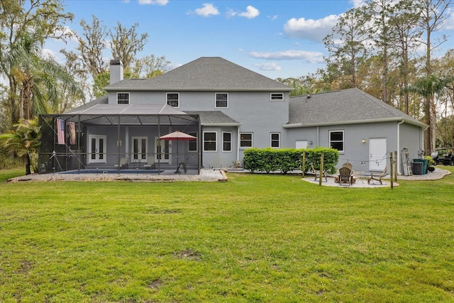 back of property featuring a patio, a chimney, a fire pit, french doors, and a lanai