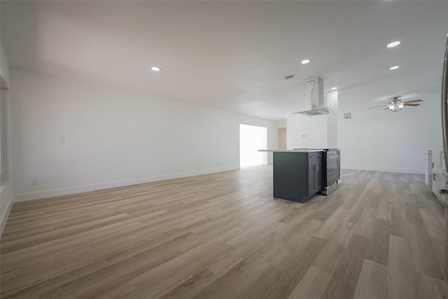 unfurnished living room with recessed lighting, baseboards, and light wood-style floors