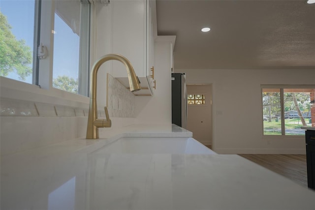 interior space with recessed lighting, freestanding refrigerator, baseboards, and wood finished floors