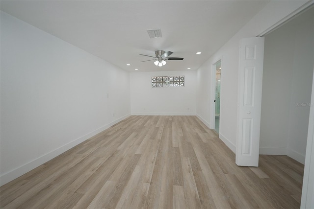 spare room featuring light wood finished floors, visible vents, ceiling fan, and baseboards