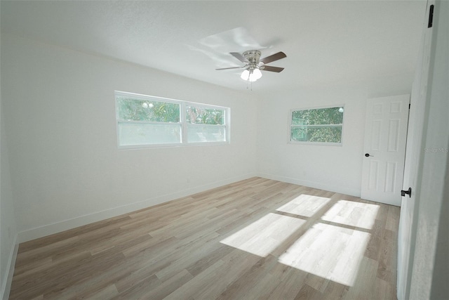 empty room with baseboards, light wood-type flooring, and ceiling fan