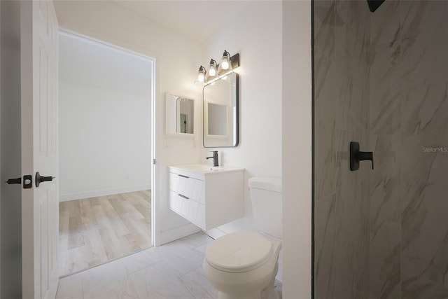 bathroom featuring a shower, toilet, and vanity