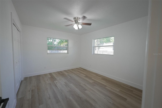 unfurnished bedroom featuring a closet, baseboards, and light wood-style flooring