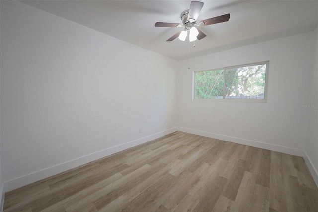 spare room featuring light wood-style floors, baseboards, and ceiling fan