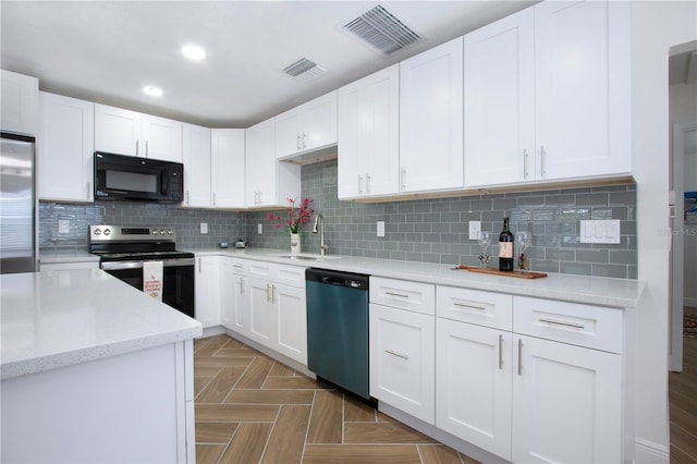 1902 Andover St Unit 198, Sun City Center, FL 33573 - kitchen with stainless steel appliances, a sink, white cabinets, recessed lighting, and tasteful backsplash