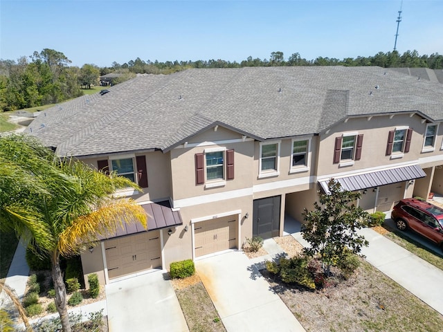 multi unit property featuring stucco siding, driveway, a shingled roof, and a garage