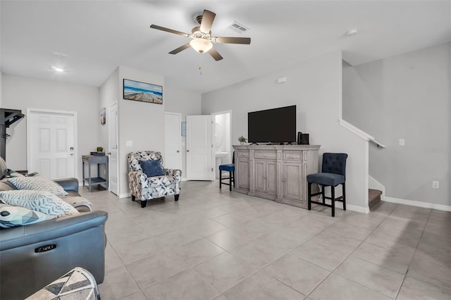 living area with visible vents, baseboards, stairs, light tile patterned flooring, and a ceiling fan