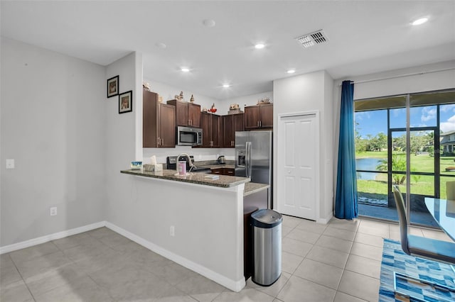 kitchen with visible vents, dark stone countertops, recessed lighting, stainless steel appliances, and a peninsula