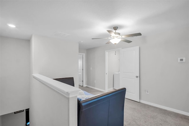 interior space with visible vents, an upstairs landing, light colored carpet, and baseboards