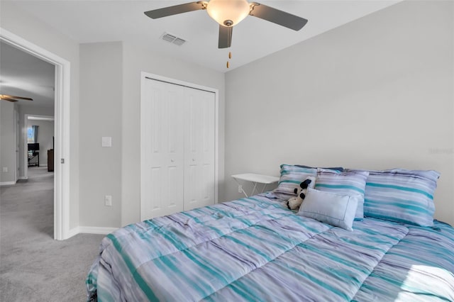 carpeted bedroom with a closet, visible vents, baseboards, and a ceiling fan