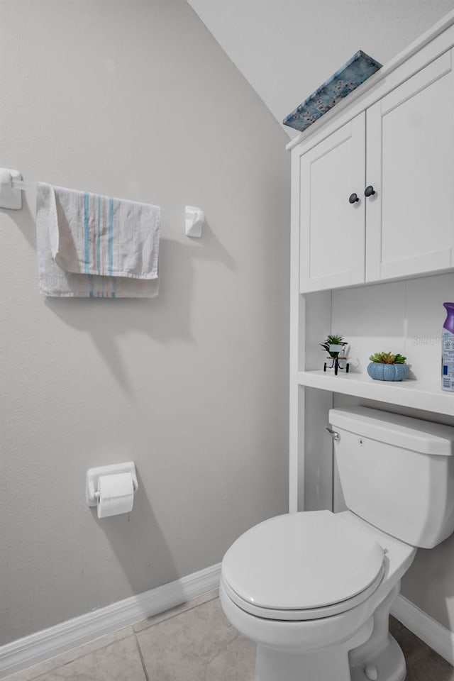 bathroom with tile patterned floors, baseboards, toilet, and vaulted ceiling