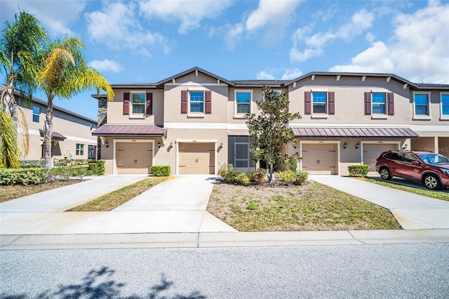 8512 Reedville St, New Port Richey, FL 34654 - view of property featuring stucco siding, an attached garage, a standing seam roof, and driveway
