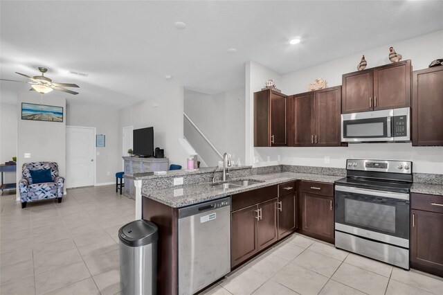 8512 Reedville St, New Port Richey, FL 34654 - kitchen featuring appliances with stainless steel finishes, a sink, a ceiling fan, open floor plan, and dark brown cabinetry