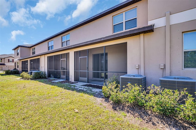 8512 Reedville St, New Port Richey, FL 34654 - rear view of property with stucco siding, central AC unit, and a yard