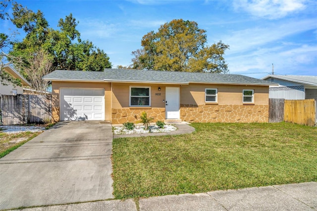 ranch-style home featuring fence, a front lawn, concrete driveway, a garage, and stone siding