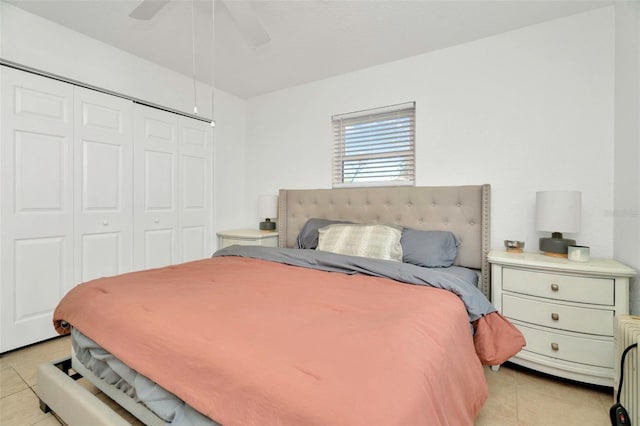 bedroom with light tile patterned flooring, a ceiling fan, and a closet