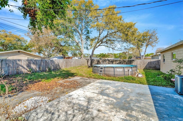 view of yard featuring a fenced in pool, central AC unit, a fenced backyard, and a patio area