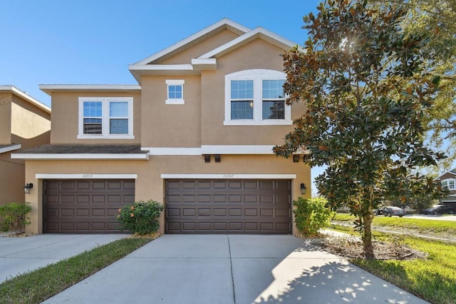 view of property featuring an attached garage, driveway, and stucco siding