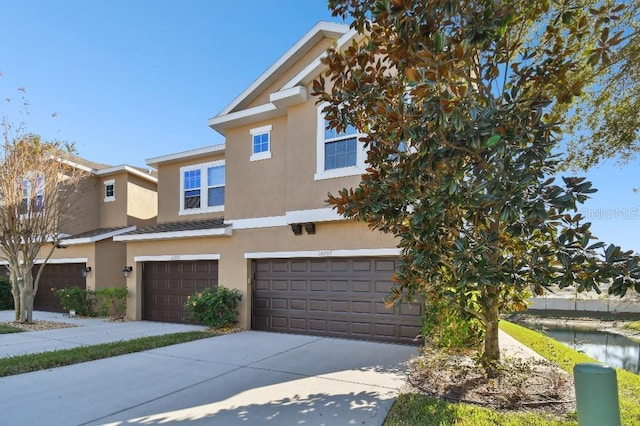 view of front of property featuring an attached garage, driveway, and stucco siding