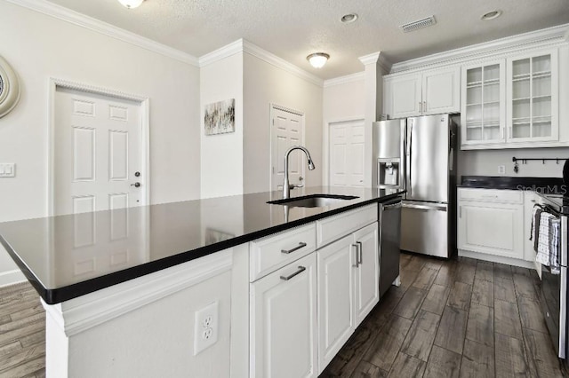 kitchen with dark countertops, visible vents, appliances with stainless steel finishes, and a sink