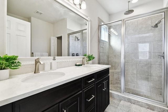 bathroom with a sink, visible vents, double vanity, and a shower stall